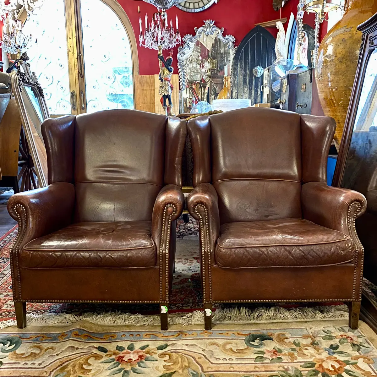 A Pair Of Dark Leather Armchairs - Sold 1